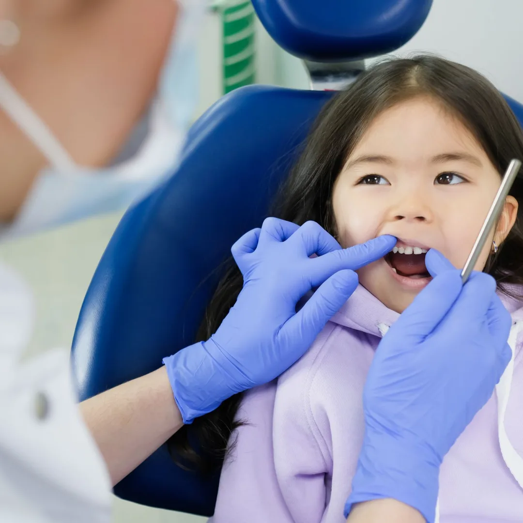 Child having their teeth examined with a dental mirror during a checkup