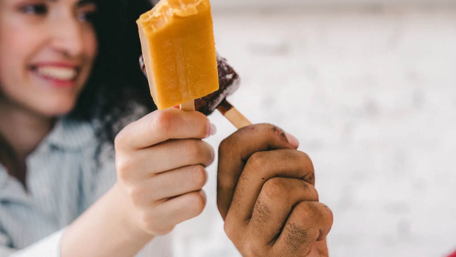 Two people sharing a popsicle on a warm summer day